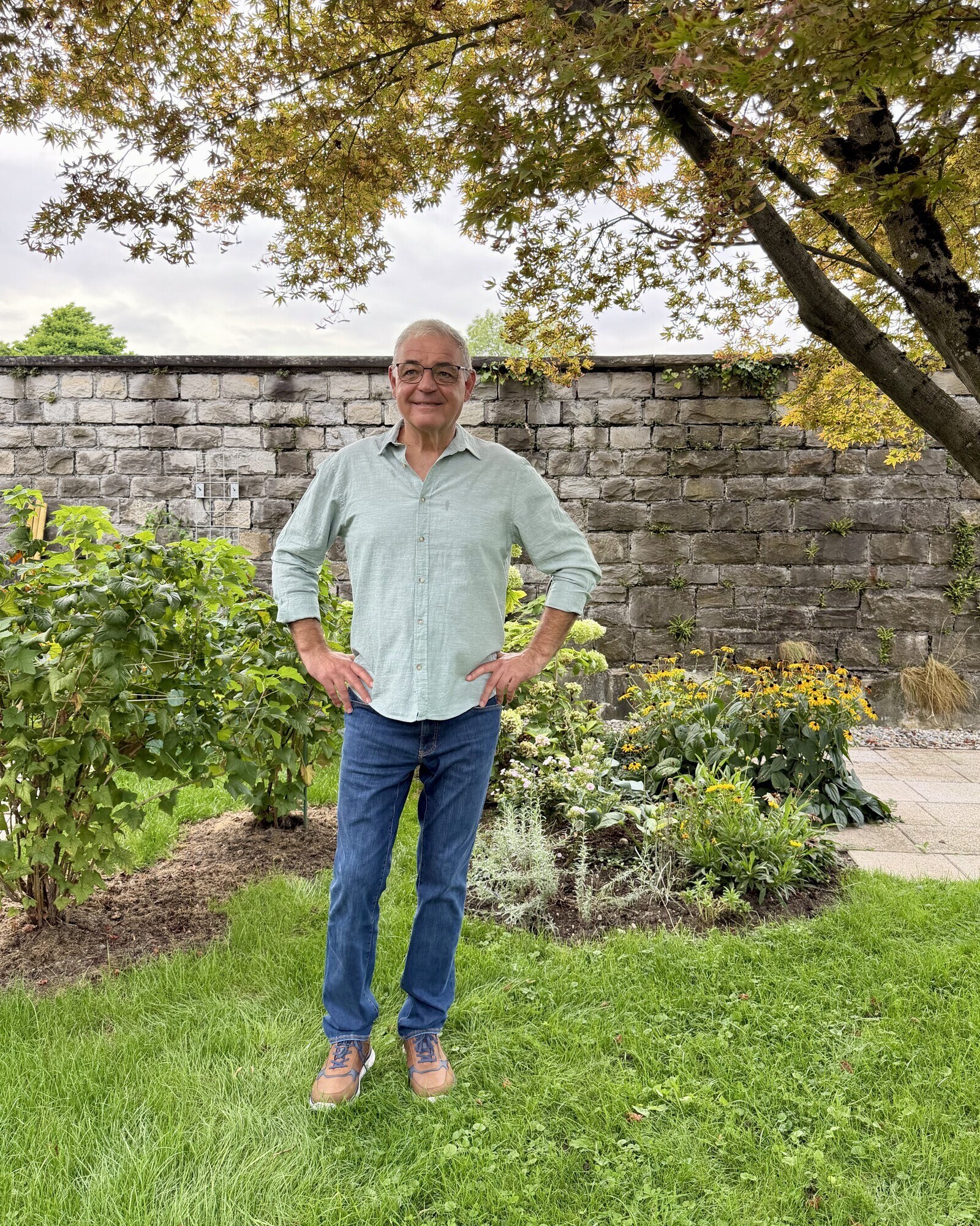 Alois Mennel steht unter einem Baum in seinem Garten in Hard